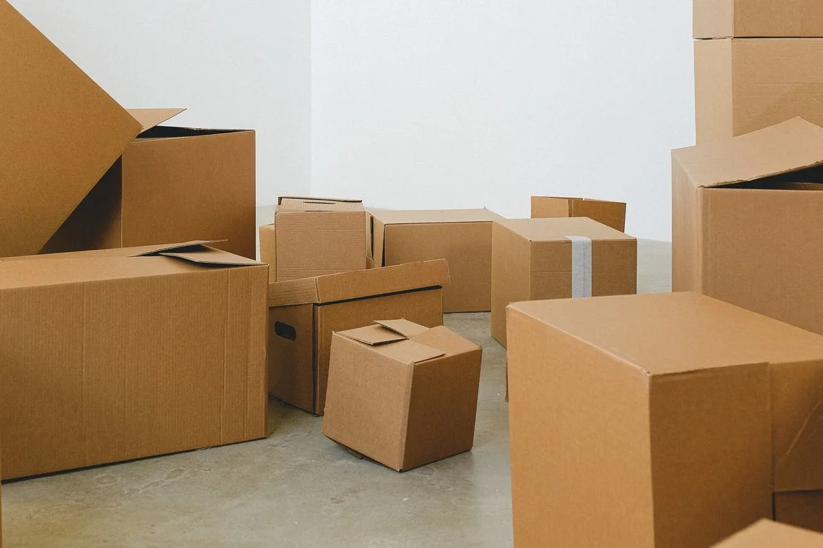Packed cardboard boxes on the floor of an empty room before a house removal