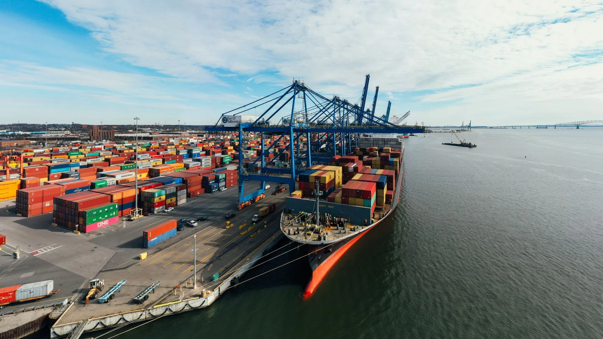 Aerial view of a container port with shipping containers and dockside cranes
