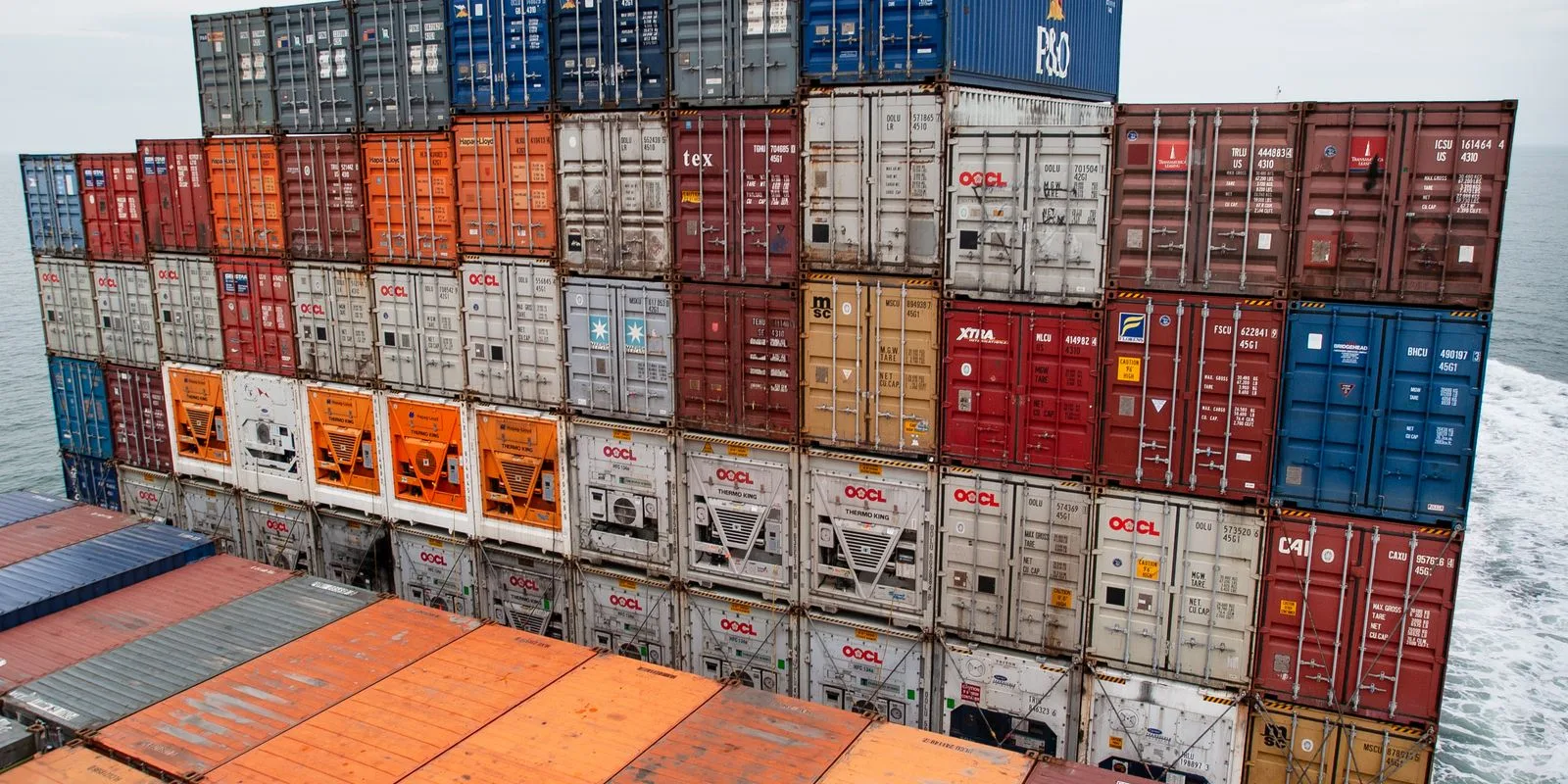 Shipping containers stacked on a cargo vessel crossing open sea