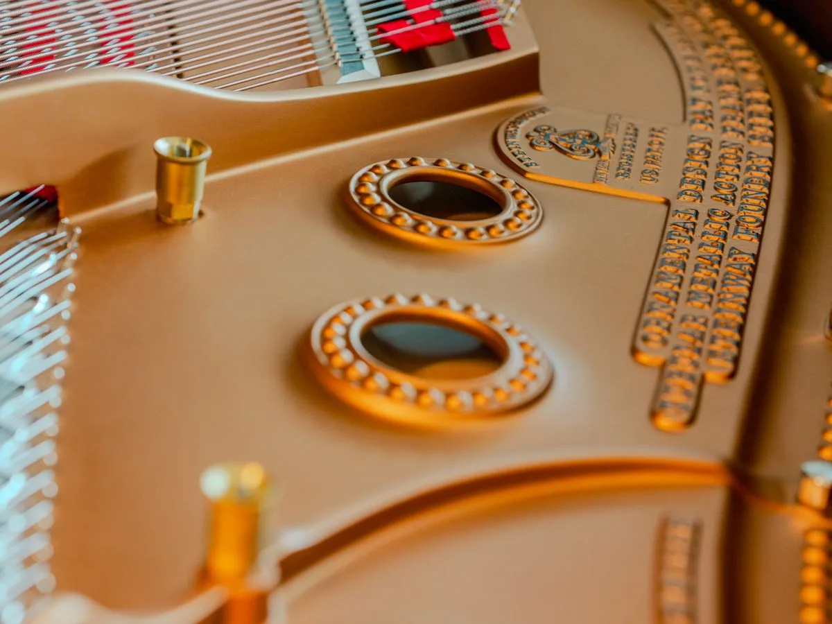Interior of a piano showing the strings, tuning pins and cast iron frame