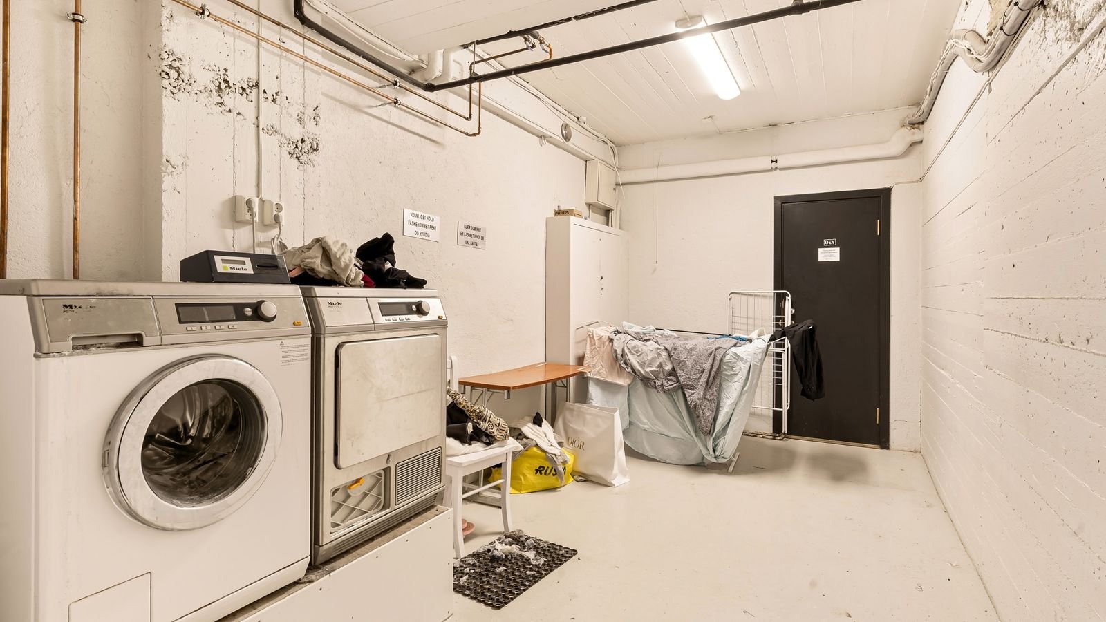 Utility room showing a washer, dryer and pipework