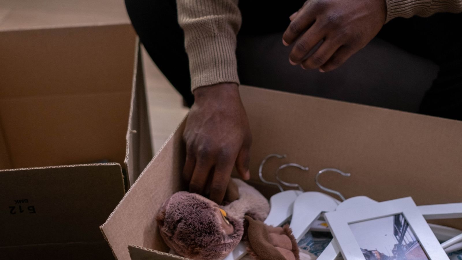 Personal belongings being lifted from a cardboard box