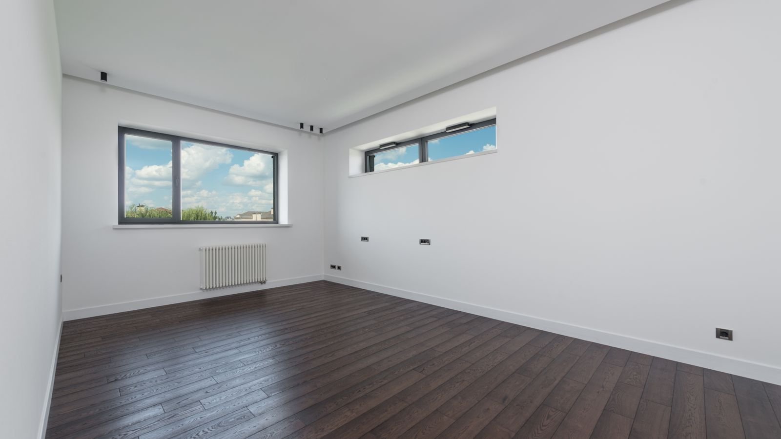Empty room with laminated floor and large windows